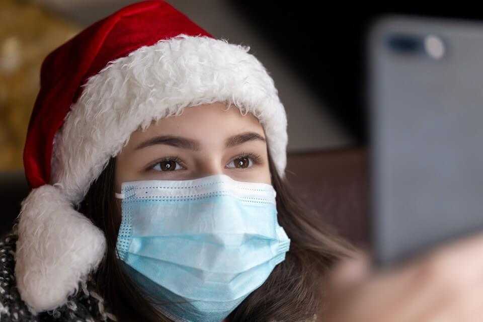 Mulher com gorro de Papai no Celular fazendo videochamada